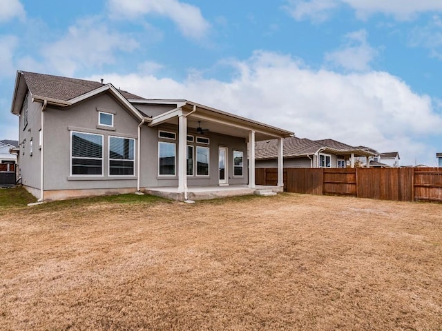 back of property featuring ceiling fan, a patio, and a lawn