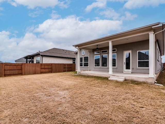 rear view of property with a patio, ceiling fan, and a lawn