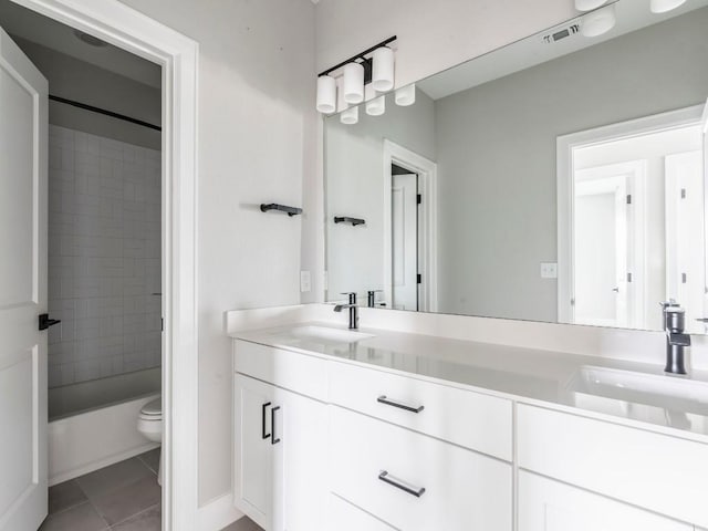 full bathroom with vanity, tiled shower / bath, tile patterned flooring, and toilet