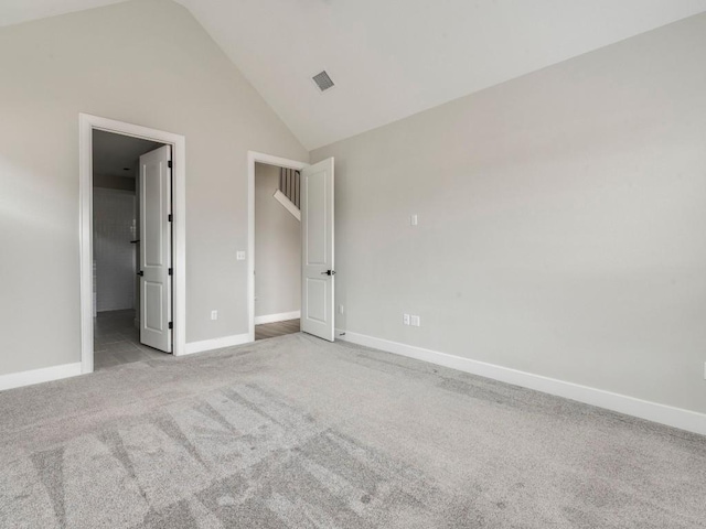 unfurnished bedroom featuring vaulted ceiling and light carpet