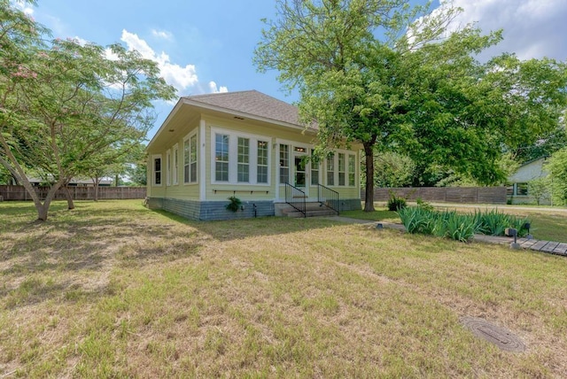 rear view of house featuring a lawn