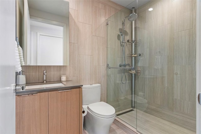 44 E Ave Unit 2310, Austin, TX 78701 - bathroom featuring toilet, a tile shower, vanity, and tile walls