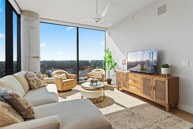 44 E Ave Unit 2310, Austin, TX 78701 - living area featuring expansive windows, wood finished floors, baseboards, and ceiling fan