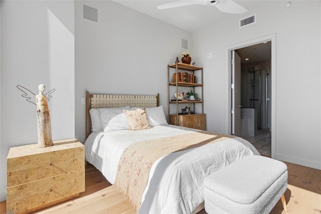 44 E Ave Unit 2310, Austin, TX 78701 - bedroom featuring wood finished floors, ensuite bathroom, and ceiling fan