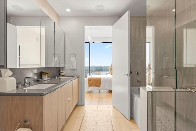 44 E Ave Unit 2310, Austin, TX 78701 - ensuite bathroom featuring double vanity, a shower with shower door, a bath, and tile patterned flooring