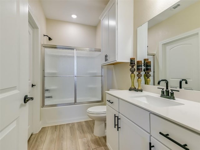 115 Lafayette St, Georgetown, TX 78633 - full bathroom featuring vanity, toilet, wood finished floors, shower / bath combination with glass door, and recessed lighting