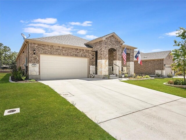 115 Lafayette St, Georgetown, TX 78633 - view of front facade with a garage, concrete driveway, a front lawn, and brick siding