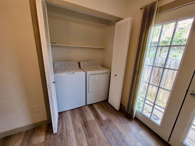 washroom with washer and clothes dryer and light hardwood / wood-style flooring