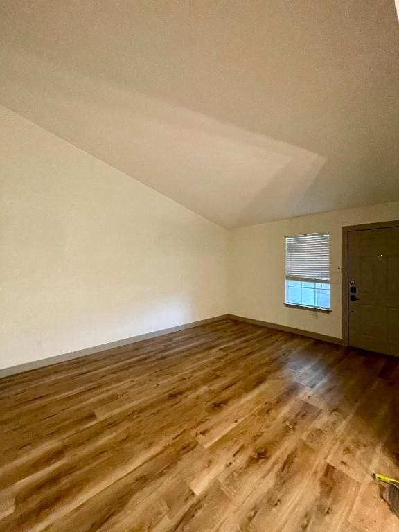 additional living space with vaulted ceiling and hardwood / wood-style floors