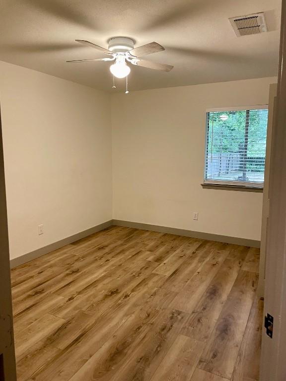 empty room featuring ceiling fan and light hardwood / wood-style flooring