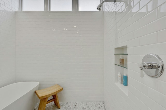 bathroom with a tub, a healthy amount of sunlight, and tile walls