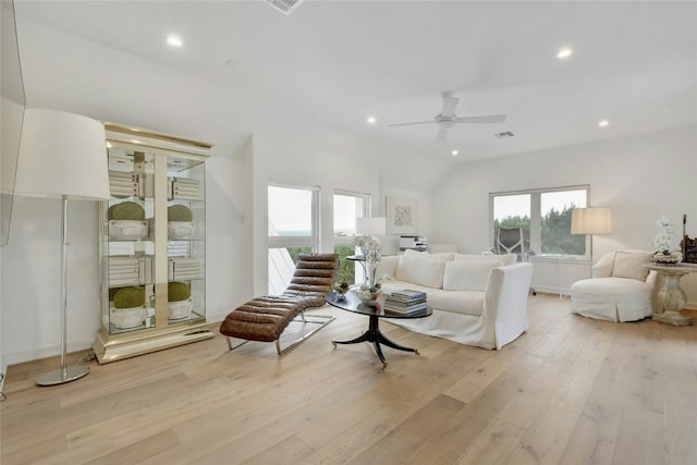 living room with ceiling fan, vaulted ceiling, and light hardwood / wood-style flooring