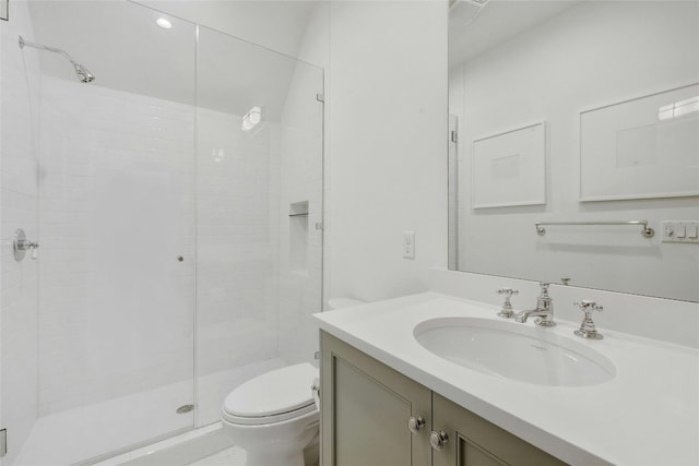 bathroom featuring a shower with door, vanity, and toilet