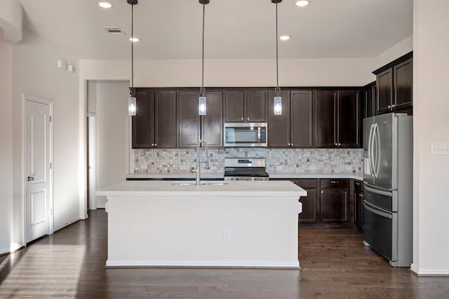 kitchen with sink, decorative light fixtures, a center island with sink, dark hardwood / wood-style flooring, and stainless steel appliances