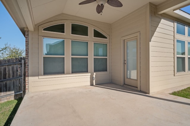 entrance to property with ceiling fan and a patio area