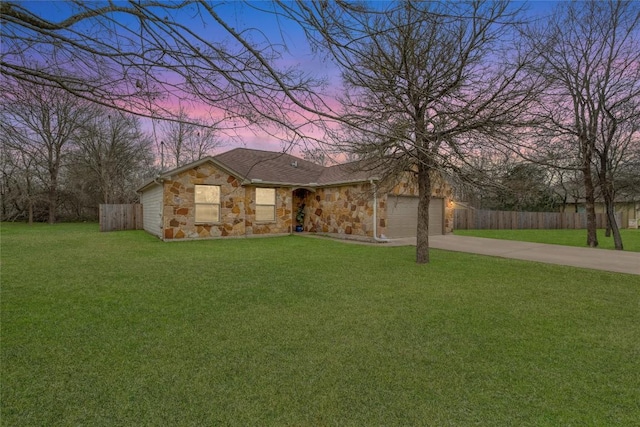 ranch-style home featuring a garage and a yard