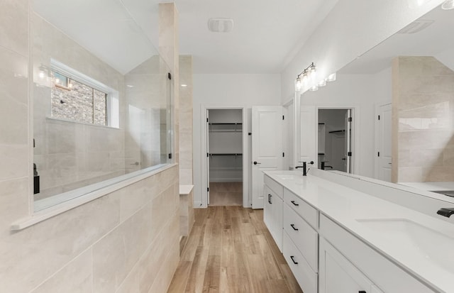 237 Silver Ridge Dr, Georgetown, TX 78633 - full bathroom featuring a tile shower, wood finished floors, a spacious closet, and double vanity