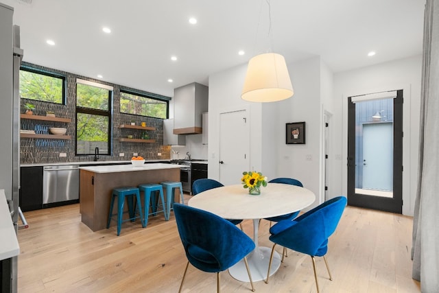 dining area with light wood-type flooring and recessed lighting