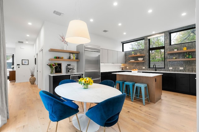 dining space with light wood-style flooring, visible vents, and recessed lighting