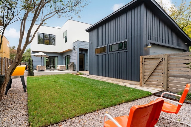 back of house with a yard, board and batten siding, a patio area, and fence private yard