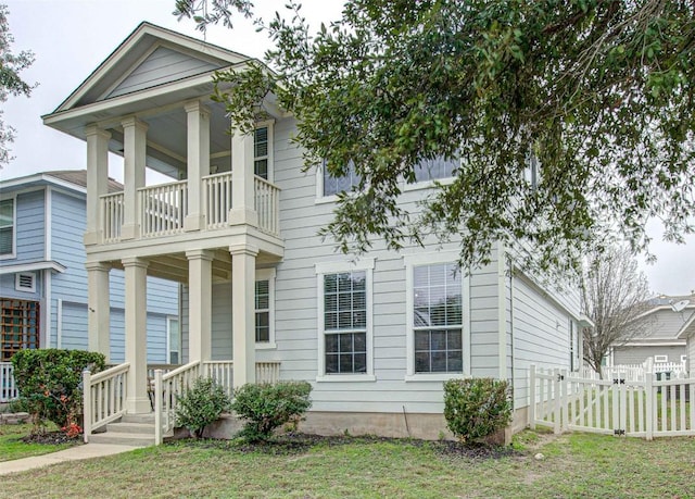 greek revival house with a porch, a balcony, and a front lawn