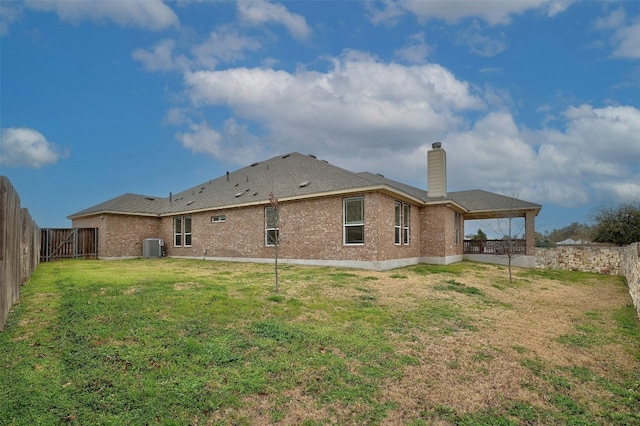 1228 Brenham Ln, Leander, TX 78641 - back of house featuring a chimney, brick siding, and central AC unit