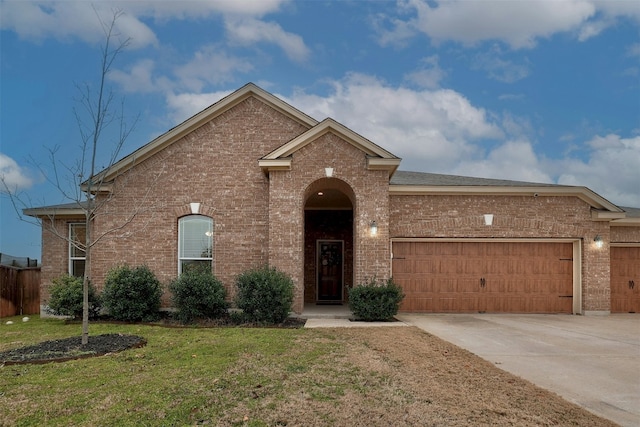 1228 Brenham Ln, Leander, TX 78641 - view of front of property featuring brick siding, an attached garage, concrete driveway, and a front lawn