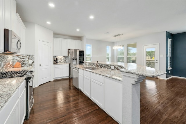 1228 Brenham Ln, Leander, TX 78641 - kitchen featuring appliances with stainless steel finishes, backsplash, a sink, a center island with sink, and dark wood finished floors