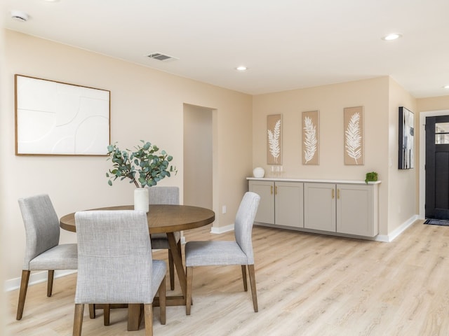 dining space featuring light wood finished floors, baseboards, visible vents, and recessed lighting