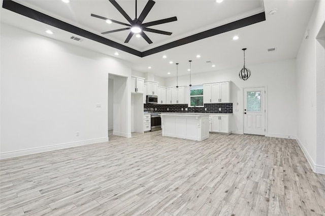 kitchen with white cabinetry, tasteful backsplash, a center island, pendant lighting, and stainless steel appliances