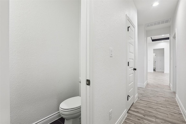 bathroom with hardwood / wood-style flooring and toilet