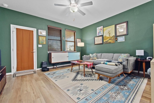 living room with light hardwood / wood-style flooring and ceiling fan