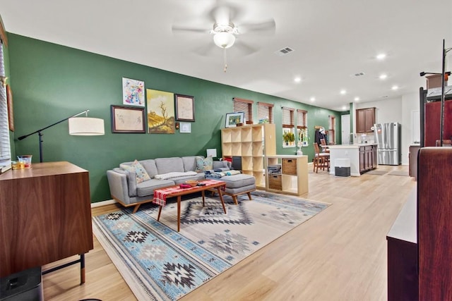 living room with ceiling fan and light wood-type flooring