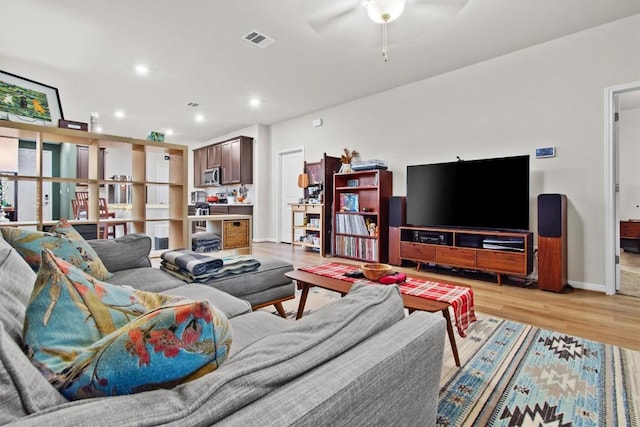 living room featuring ceiling fan and light wood-type flooring