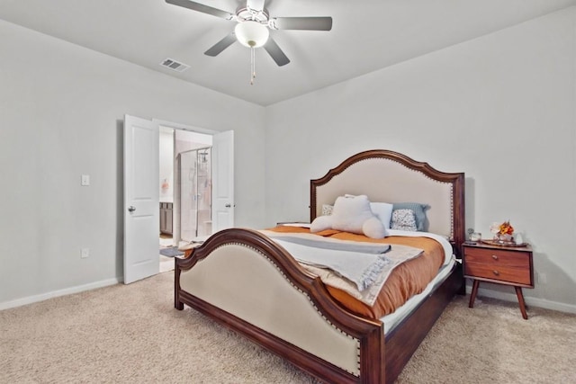 bedroom with ensuite bath, light colored carpet, and ceiling fan