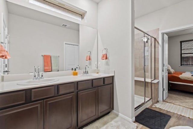 bathroom featuring a shower with door and vanity