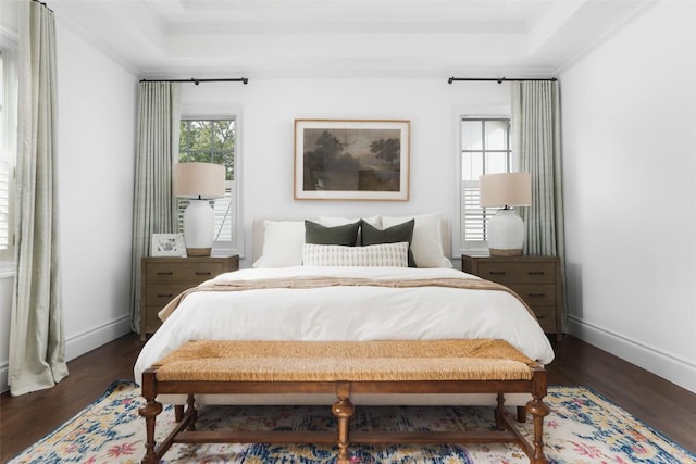 bedroom featuring ornamental molding, dark hardwood / wood-style flooring, a raised ceiling, and multiple windows