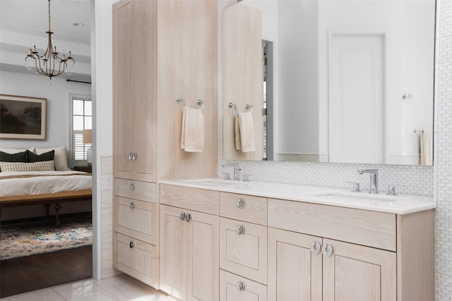 bathroom featuring vanity, backsplash, and an inviting chandelier