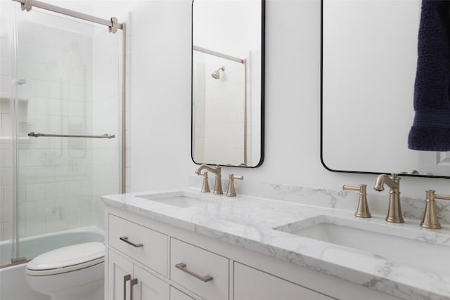 full bathroom featuring enclosed tub / shower combo, vanity, and toilet