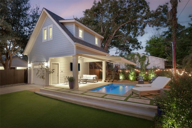 back house at dusk featuring a fenced in pool, a patio, and an outdoor hangout area