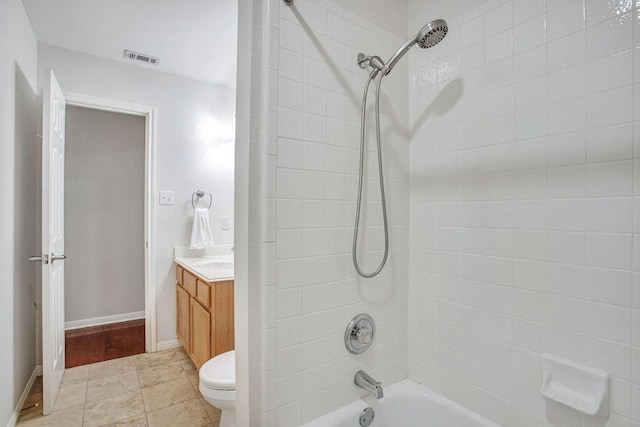 full bathroom featuring tiled shower / bath, vanity, and toilet