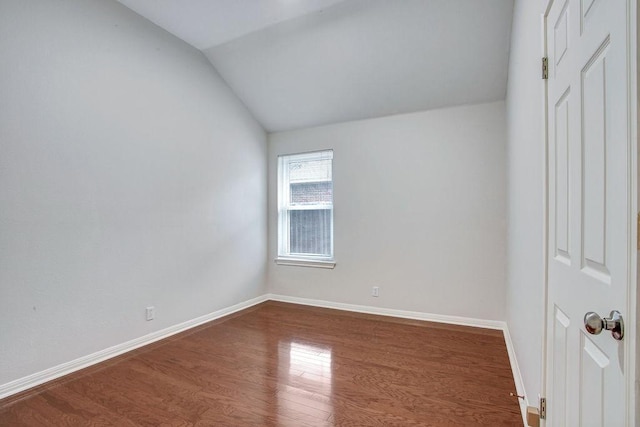 unfurnished room featuring lofted ceiling and hardwood / wood-style flooring