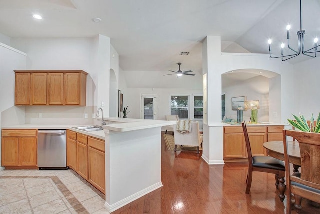 kitchen featuring lofted ceiling, sink, dishwasher, hanging light fixtures, and kitchen peninsula