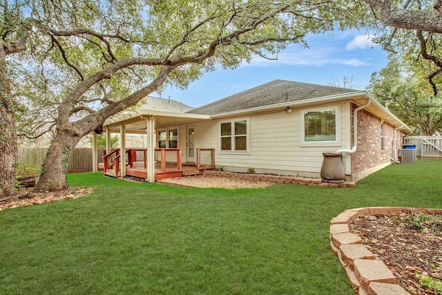 rear view of property featuring a wooden deck, central AC unit, and a lawn