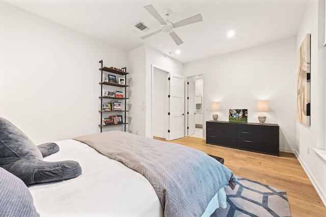 bedroom featuring ensuite bath, light hardwood / wood-style floors, and ceiling fan