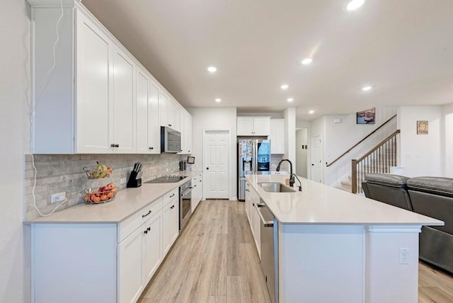 19312 Forman Dr, Pflugerville, TX 78660 - kitchen featuring stainless steel appliances, a sink, tasteful backsplash, light wood-type flooring, and recessed lighting