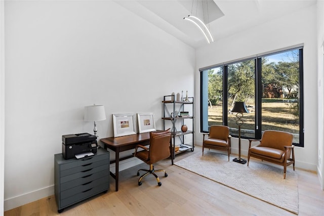 office space featuring vaulted ceiling and light wood-type flooring