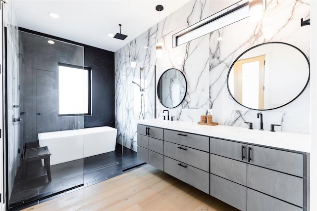 bathroom with vanity, hardwood / wood-style flooring, a tub, and tile walls