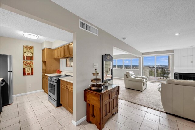 307 Poker Chip Unit 116, Horseshoe Bay, TX 78657 - kitchen featuring appliances with stainless steel finishes, a textured ceiling, open floor plan, light tile patterned flooring, and light carpet