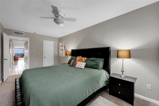 307 Poker Chip Unit 116, Horseshoe Bay, TX 78657 - bedroom featuring carpet, a textured ceiling, and a ceiling fan
